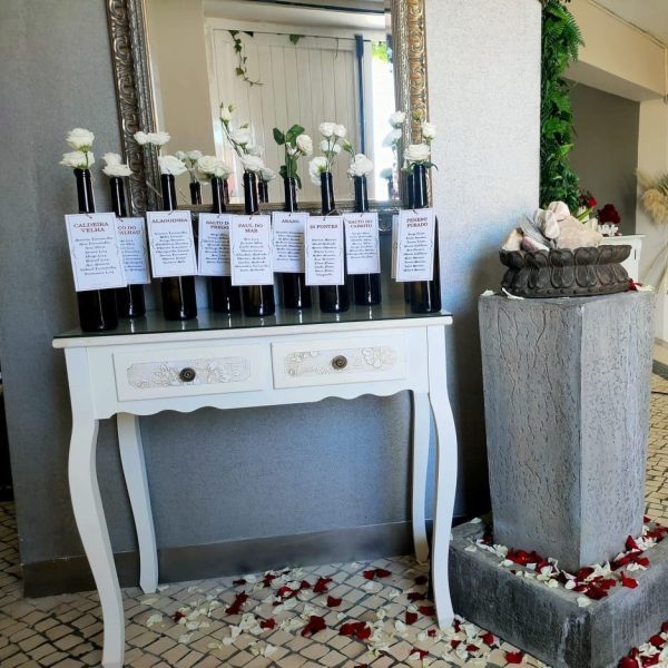 Placard de mesas cartões garrafas brancos aplicados em garrafas escuras com flores brancas Cátia Silva Atelier